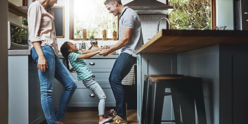 Family hanging out in kitchen together.