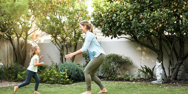 mom and daughter playing in healthy green lawn