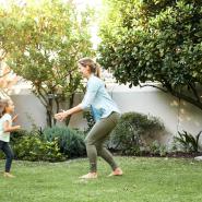 mom and daughter playing in healthy green lawn